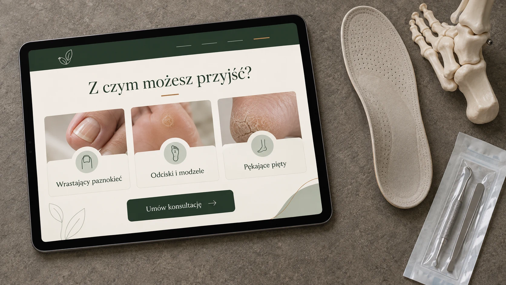 Tablet ze stroną gabinetu podologicznego obok wkładki i modelu anatomicznego stopy